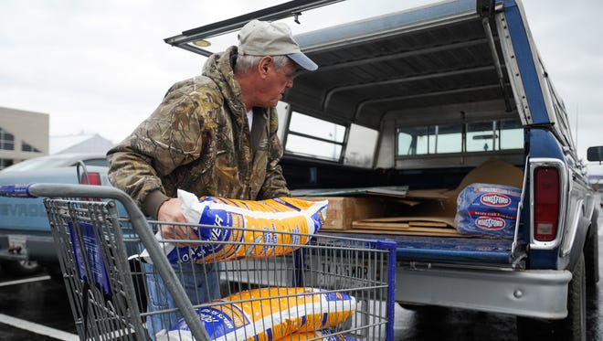 Denis Schenk loads bags of rock salt into the bed of his pick-up truck on the West Side of Evansville Thursday. “I hope I don’t have to use it,” Schenk said. 
Many people were out buying rock salt due to the prediction of ice and snow Thursday evening into Friday afternoon.