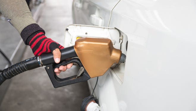 Men hold Fuel nozzle to add fuel in car at filling station