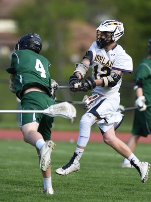 Highland High School's Kyle Merget shoots past Cornwall's Conor Havey to score during a May 11 game in Highland.