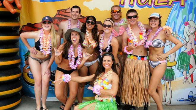 People celebrate with leis and grass skirts during Salt River Tubing's Hawaiian Mega Hula event.