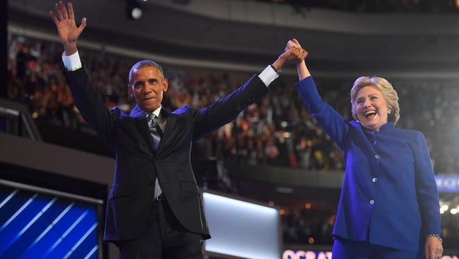 President Barack Obama and Hillary Clinton stand on stage after Obama spoke during the 2016 Democratic National Convention at Wells Fargo Center on Wednesday, July27, 2016.