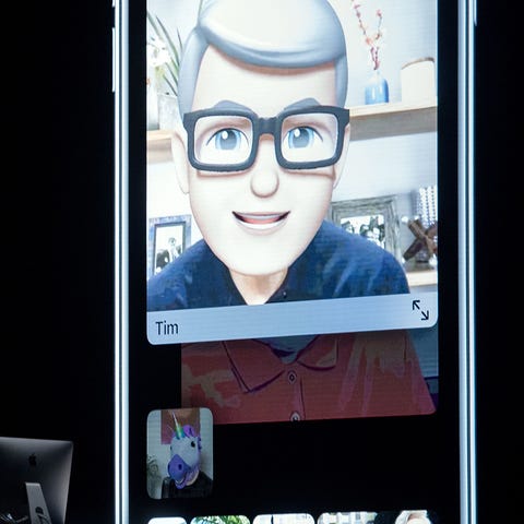 Apple CEO Tim Cook ,top , speaks using his Memoji...