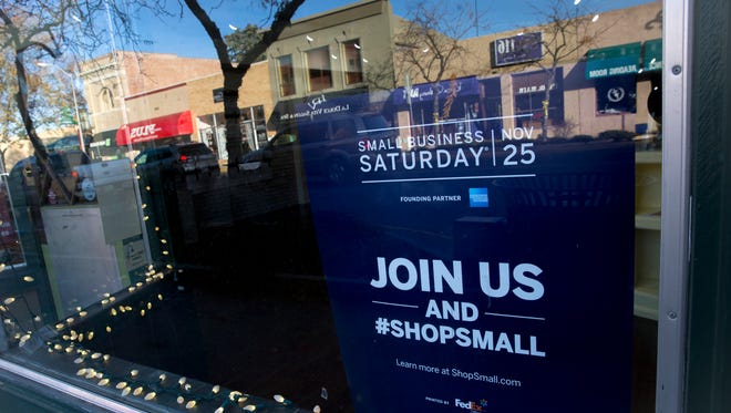 A poster promoting Small Business Saturday hangs on the Complete Streets Headquarters on Tuesday, Nov. 21, 2017  at 119 East Main Street