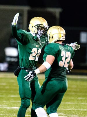 Iowa City West's Bryson Adcock (22) congratulates teammate Mason Koch (32) as he comes off the field as time winds down versus Cedar Rapids Prairie during the second half of play in Iowa City during the first game of the playoffs on Wednesday, October 28, 2015. The Trojans advanced with a 35-20 win. (Justin Torner/Freelance for the Press-Citizen)
