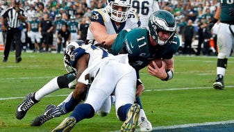 Eagles quarterback Carson Wentz dives into the end zone late in the third quarter Sunday. He apparently hurt his knee on the play, which didn't count because of a penalty. Wentz left the game shortly after that.