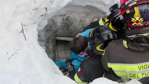 This frame from video shows Italian firefighters extracting a boy alive from under snow and debris of an hotel that was hit by an avalanche on Wednesday, in Rigopiano, central Italy, Friday, Jan. 20, 2017.