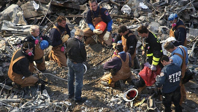 -

-Text: RETRANSMITTED WITH ALTERNATIVE CROP AND ENHANCED IMAGE QUALITY--Rescue workers remove their hats and bow their heads at the site of the World Trade Center in New York, Friday, Sept. 28, 2001. Workers continue clearing debris from the site of the September 11 terrorist attacks. (AP Photo/Shawn Baldwin)