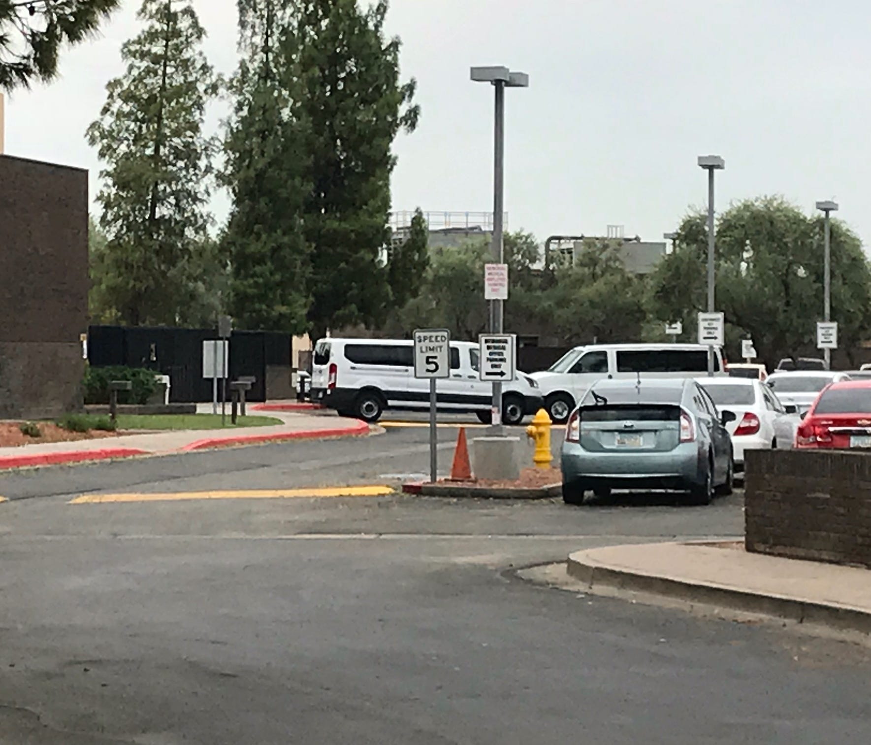 White vans are seen waiting outside a shelter in Phoenix that has been housing migrant children separated from their parents on July 10, 2018.