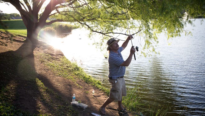 Frank Mantz of Phoenix casts his line while fishing at Green Valley Park in Payson on July 29, 2014.