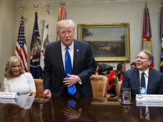 Trump takes his seat between Paula White of the New