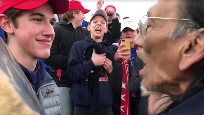 Kentucky high school student Nick Sandmann, left, is seeking $250 million from The Washington Post for being "targeted and bullied" by the newspaper after his confrontation with Native American elder Nathan Phillips at the Lincoln Memorial in January.