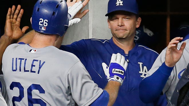 Los Angeles Dodgers hitting coach Turner Ward, right, congratulates Chase Utley after Utley scored on Corey Seager's second-inning single in a baseball game against the New York Yankees in New York, Monday, Sept. 12, 2016. (AP Photo/Kathy Willens)