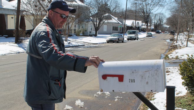 Bob Kirk delivers mail to a curbside box on Division Avenue in Jackson.
