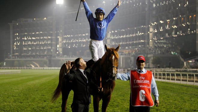 Silvestre De Sousa, rider of African Story from Great Britain, celebrates after he wins the world's richest horse race Dubai World Cup at Meydan racecourse in Dubai, United Arab Emirates, Saturday, March 29, 2014. (AP Photo/Kamran Jebreili)