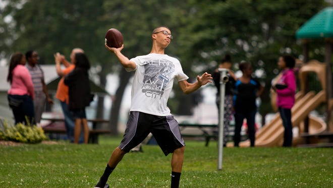 Jaylen Shipp, 15, of Port Huron, throws a football with friends during a Save Our Neighborhoods and Streets Outreach barbeque Saturday, August 29, 2015 at Pine Grove Park in Port Huron.