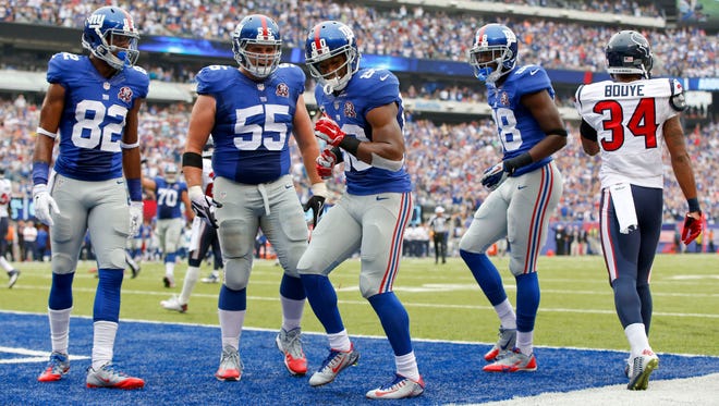 Giants wide receiver Victor Cruz (80), celebrates with Rueben Randle (82), J.D. Walton (55) and Corey Washington (88) after scoring a touchdown against the Houston Texans in the second quarter on Sunday.