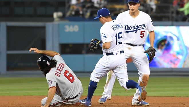 Washington Nationals third baseman Anthony Rendon (6) slides in safely ahead of Los Angeles Dodgers catcher Austin Barnes (15) during the ninth inning at Dodger Stadium.