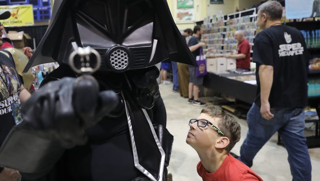 Rose Tuski of Spring City, Pa. is dressed as Dark Helmet from the movie Spaceballs as a curious admirer, Phillip Gerola 8 of Hacketstown looks to see whose inside the costume. 