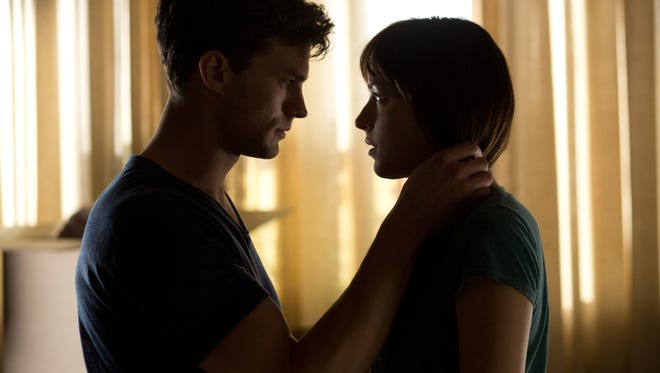 DAKOTA JOHNSON as Anastasia Steele and JAMIE DORNAN as Christian Grey in a scene from the motion picture "Fifty Shades of Grey."