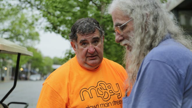 Steve Bultinck talks to Ron Smith Saturday, May 9, 2015 after he and other organizers decided to cancel the season's first Mosey Down Main Street event due to heavy rain.