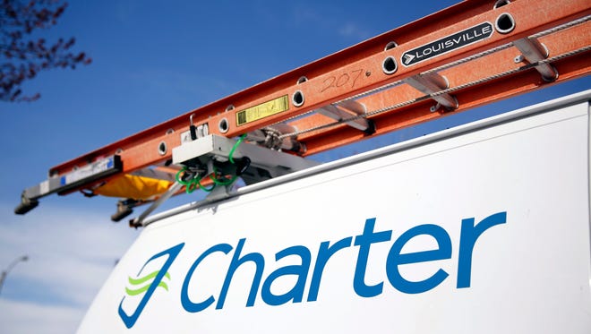 This April 1, 2015 photo shows a Charter Communications van in St. Louis. Charter Communications is close to buying Time Warner Cable for about $55 billion, two people familiar with the negotiations said Monday, May 25, 2015. (AP Photo/Jeff Roberson)