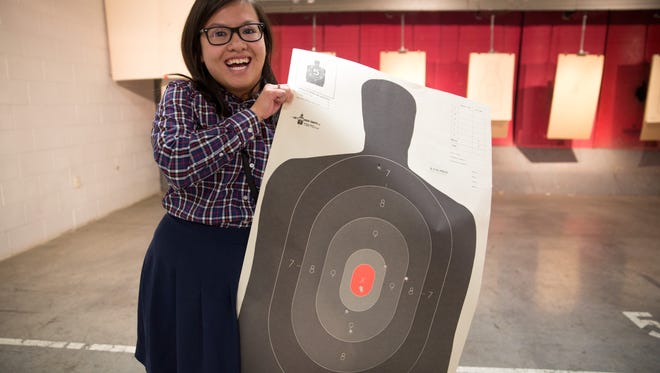 Des Moines Register reporter Linh Ta holds her target after shooting Thursday, Jan. 7, 2016.