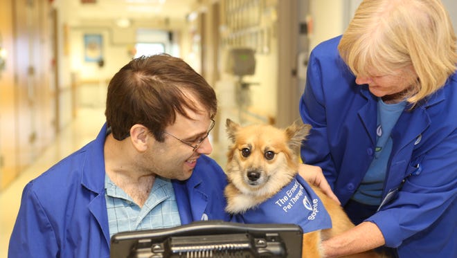 Chris Kent, a volunteer at Hunterdon Medical Center is greeted by Sophie, a pet therapy dog and Betty Ann Dhein, a volunteer at Hunterdon Medical Center. Betty brings Sophie once a week to visit patients and staff at the hospital.