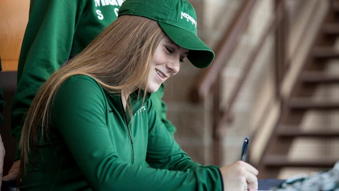 Senior Hannah Jones smiles as she signs to commit to Michigan State University in front of friends and family as part of National Signing Day Wednesday, Feb. 3, 2016 at Port Huron Northern High School.