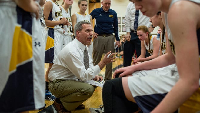 Port Huron Northern coach Mark Dickinson talks with players in a huddle during a state quarterfinal basketball game Tuesday, March 15, 2016 at Fenton High School.