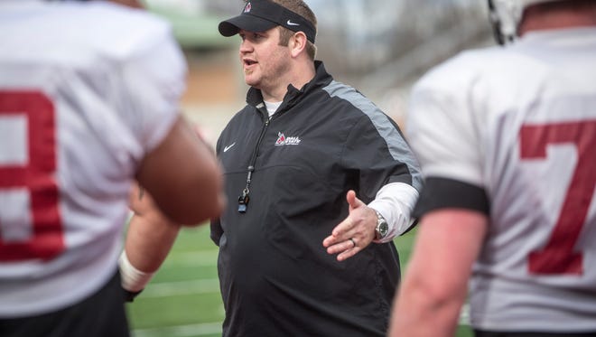 Kyle DeVan, Ball State’s new offensive line coach, talks strategy with the team of offensive linemen during drills at Ball State’s spring practice on Friday afternoon at Scheumann Stadium. DeVan will be utilizing Ball State’s already established veterans to help bookend a new core of an offensive line.