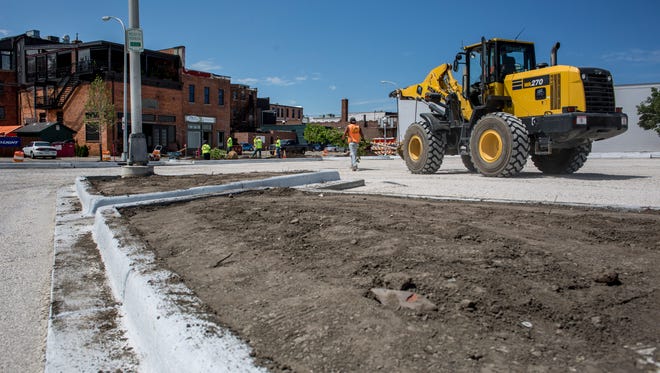 Curbs and sidewalks have been poured as contractors work on landscaping Thursday, June 23, 2016 at Quay and Fort streets in Port Huron. The parking lot is expected to be completed by June 30.