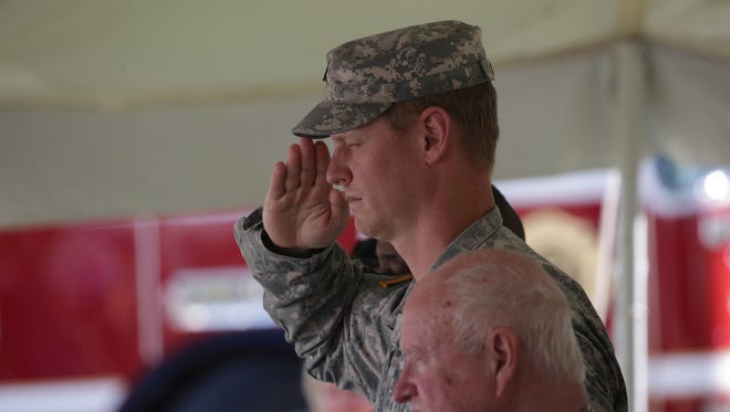 A Never Forget Tribute remembering 9-11 was held by Klingner-Cope Funeral Home on Sunday afternoon. MSU ROTC Cadet and Army veteran Christopher Shortt salutes during the singing of the National Anthem.