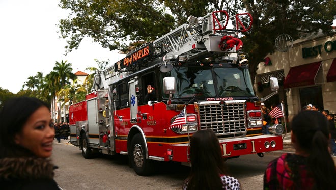 FILE - People wave at a passing fire truck during the 19th annual Martin Luther King, Jr. Day Parade in downtown Naples on Monday, Jan. 18, 2016.
