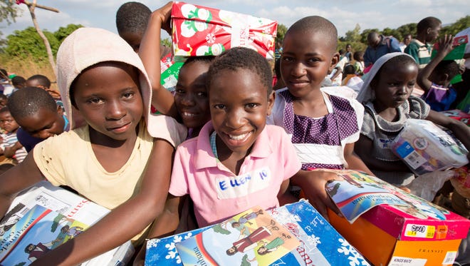 Children in Malawi show the shoeboxes they received through Operation Christmas Child.