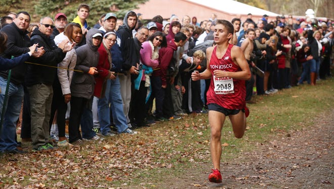 20024276A  10/29/16  Mahwah, N.J.  Don Bosco's David Rosas runs to the finish line to win the Boys race with a crowd watching at the Lou Molino Bergen County XC Meet of Champions  at Darlington Park.  JIM ALCORN/SPECIAL TO THE RECORD