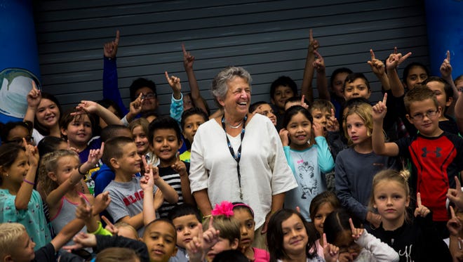 Laura Lehrich, 71, center, laughs as her students do the #1 sign after she received the senior volunteer of the year award at Seagate Elementary on Friday, April 7, 2017. The Outstanding School Volunteer Award is presented annually to a student, adult, and senior volunteer who has shown outstanding dedication and commitment to quality education in Florida. "This is the most rewarding thing I've ever done, really making an impact on a child's life," says Lehrich. "I'm giving back and getting back so much."