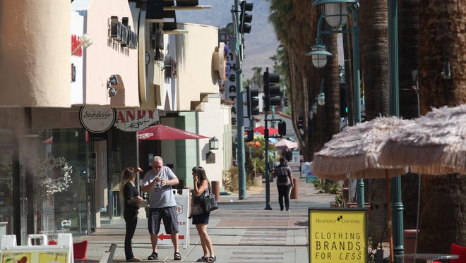 Shoppers and visitors stroll downtown on Palm Canyon Drive in Palm Springs on July 27, 2017. 