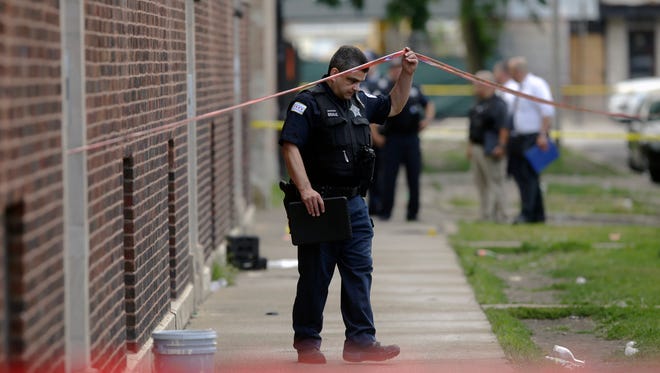 Chicago Police officers and detectives investigate a shooting on Sunday, August 5, 2018.