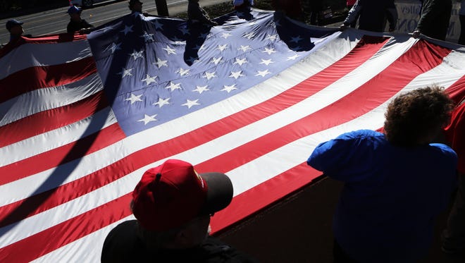 Marchers carry a giant American flag in 2014 in Albany for the annual Veterans Day Parade.