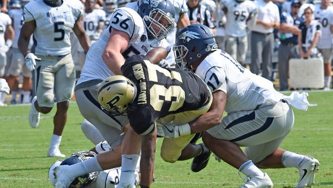 Wolf Pack linebacker Alex Bertrando and Jarid Joseph team up to try and stop Purdue running back Brian Lankford-Johnson during a game last month.