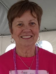 Carolyn Edwards, a two-year breast cancer survivor from Williamston, finished Sunday's Komen Race for the Cure with photo of her seven grandchildren pinned beneath her race number.