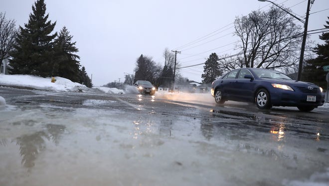 Vehicles drive east along Capital Drive during icy and slushy road conditions in Grand Chute on Tuesday.