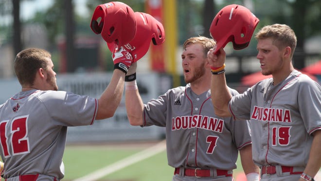 Joe Robbins (12) touches helmets with UL teammates Kyle Clement (7) and Hunter Kasuls (19) after his two-run homer against Arizona last Monday.