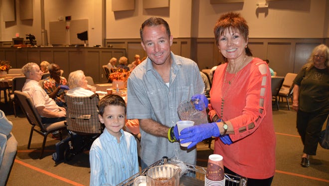 Joshua and Brian Thomas, along with Connie Owen, replenish beverages during last year's Thanksgiving meal.