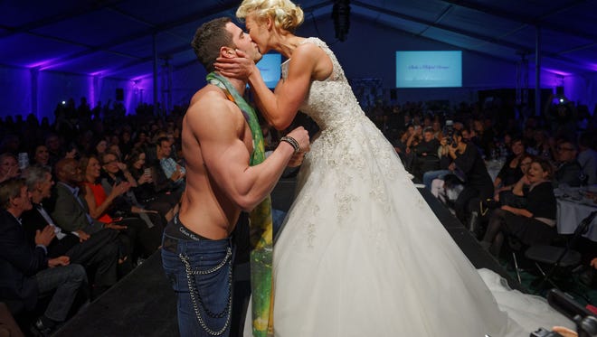 Eva Hlebowicz kisses Kyle Glickman after the couple got engaged on the runway at Fashion Week of Rochester on Oct. 17, 2015.