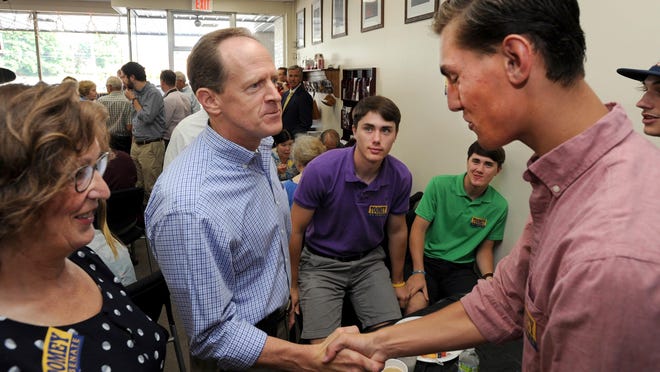 U.S. Sen. Pat Toomey, left, chats with teenagers Blake Wade, left and twin brother Logan, and Nick Spinelli, right, at the Cambria County Republican headquarters in Johnstown, Pa., where he stopped to meet with supporters on the campaign trail, Tuesday, July 19, 2016. At far left is Jackie Kulbak, chairwoman of the county's Republican party. (John Rucosky/Tribune-Democrat via AP)