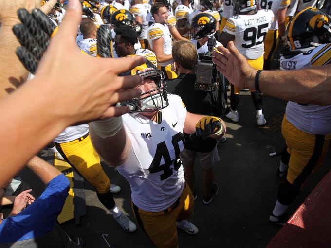 Iowa's Parker Hesse high-fives fans after the Hawkeyes'