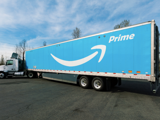 A blue Amazon delivery truck with the Amazon arrow logo and the word 