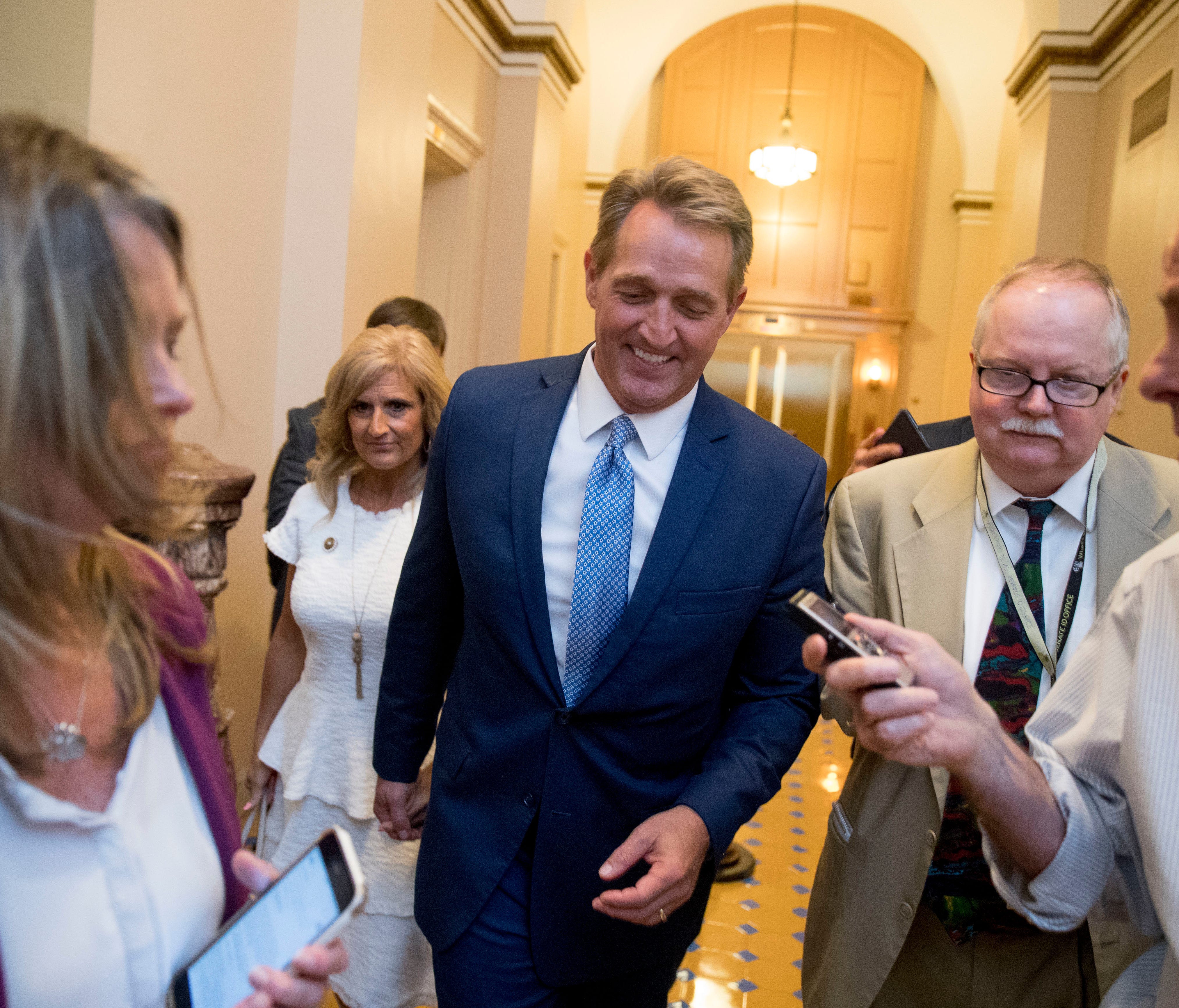 Sen. Jeff Flake, R-Ariz., accompanied by his wife, Cheryl, leaves the Capitol on Oct. 24, 2017, after announcing he won't seek re-election in 2018.