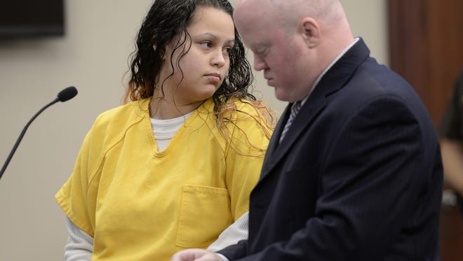 Mariah Haughton, 17,  with attorney Steven Feigelson, looks back towards her family and supporters in court in Lansing Wednesday July 15, 2015 before she is sentenced to at least four years in prison for her role in a sex trafficking ring.
